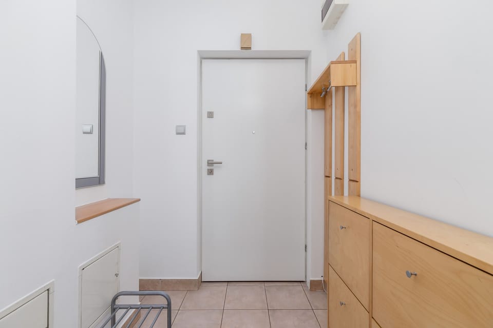 A well-lit entrance hall with wooden furniture and storage solutions.
