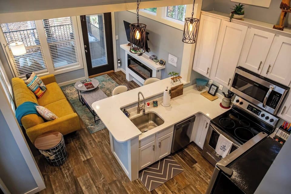 This charming open-concept space seamlessly blends the cozy living area with a fully equipped kitchen, creating a welcoming atmosphere.