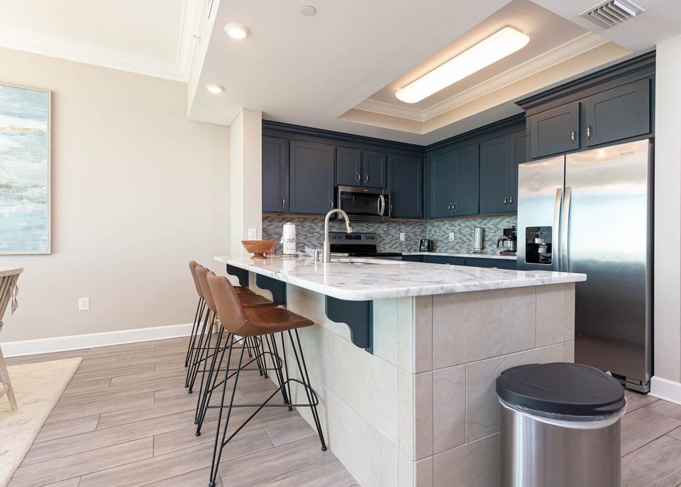 Savor fresh coffee while seated at the inviting breakfast bar, surrounded by the luxurious kitchen space