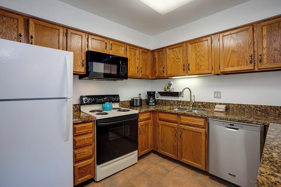 Your fully-equipped kitchen features granite counters, rich wood cabinets, and everything needed to prepare delicious home-cooked meals.