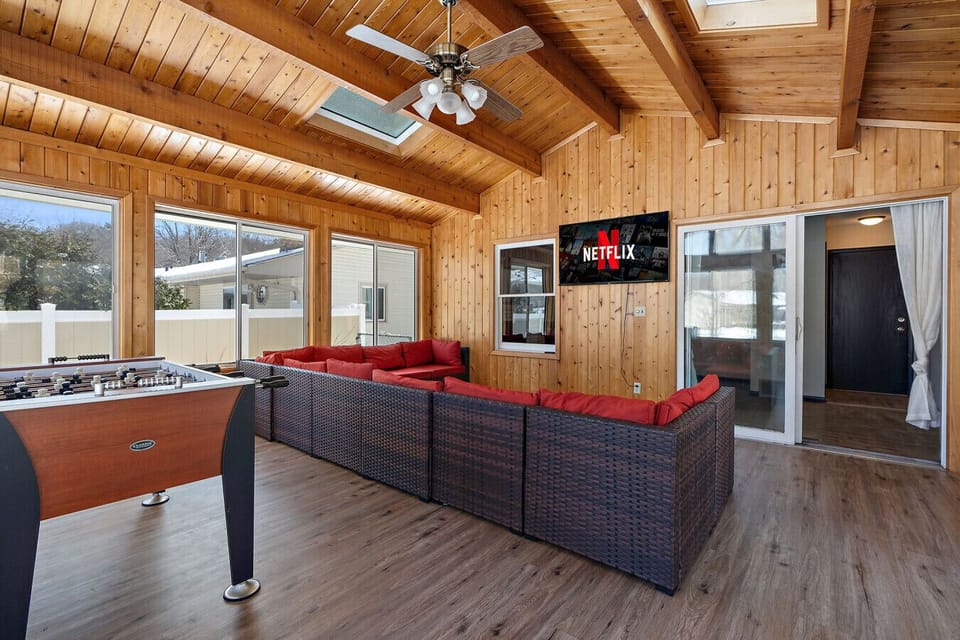 Four season porch with foosball table and plenty of seating space to gather and watch something on the 50` Roku Smart TV.