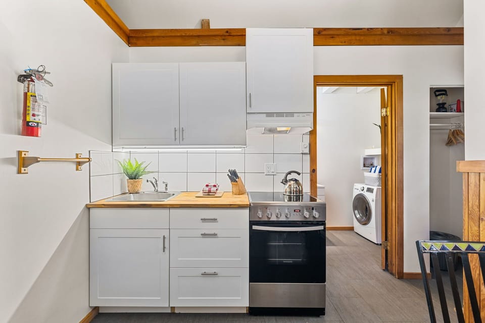Bright kitchenette with washer/dryer access and modern essentials