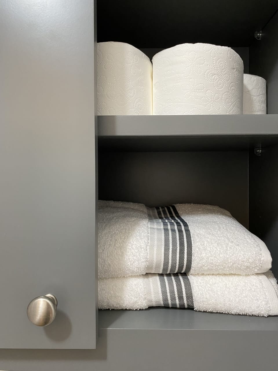 Extra towels and toilet paper above the toilet in the upstairs bath.