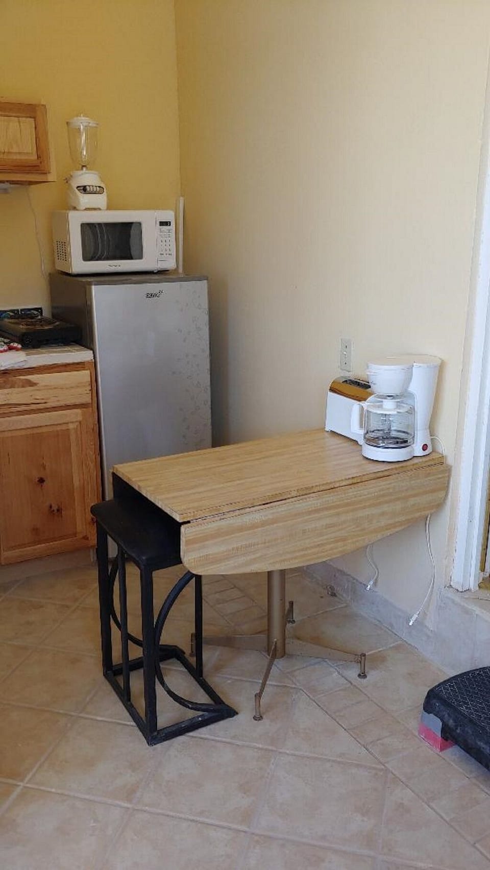 KITCHENETTE TABLE AND FRIDGE.