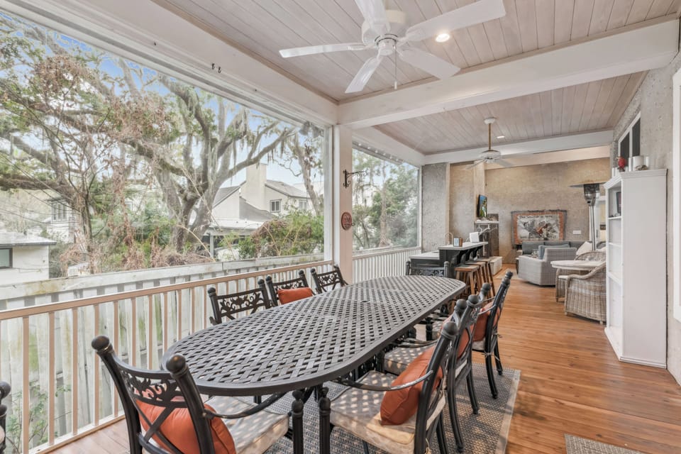 Relax on your covered balcony with outdoor dining for eight, ceiling fans, and peaceful tree views.