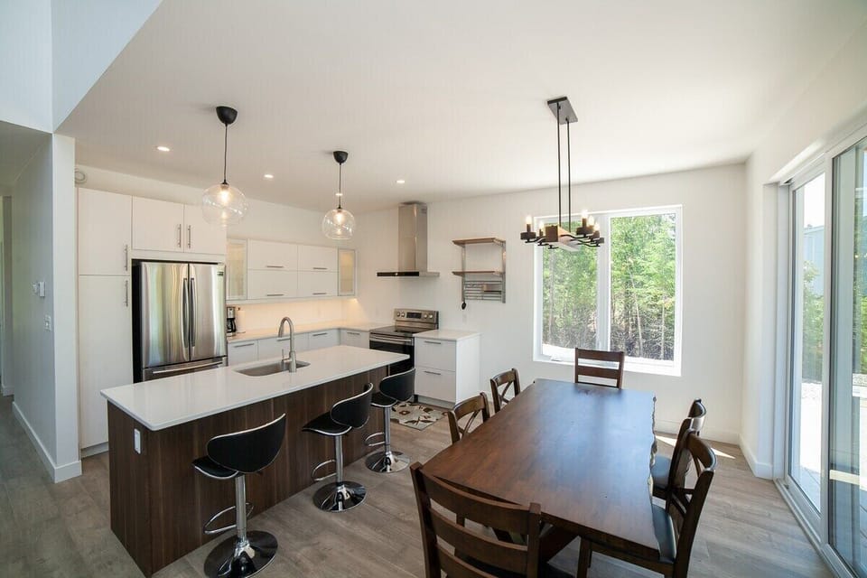 Host in style – the chef's kitchen features stainless steel appliances, quartz countertops, and open shelving for functional beauty. Gather around the dining table for laughter and lakeside meals.