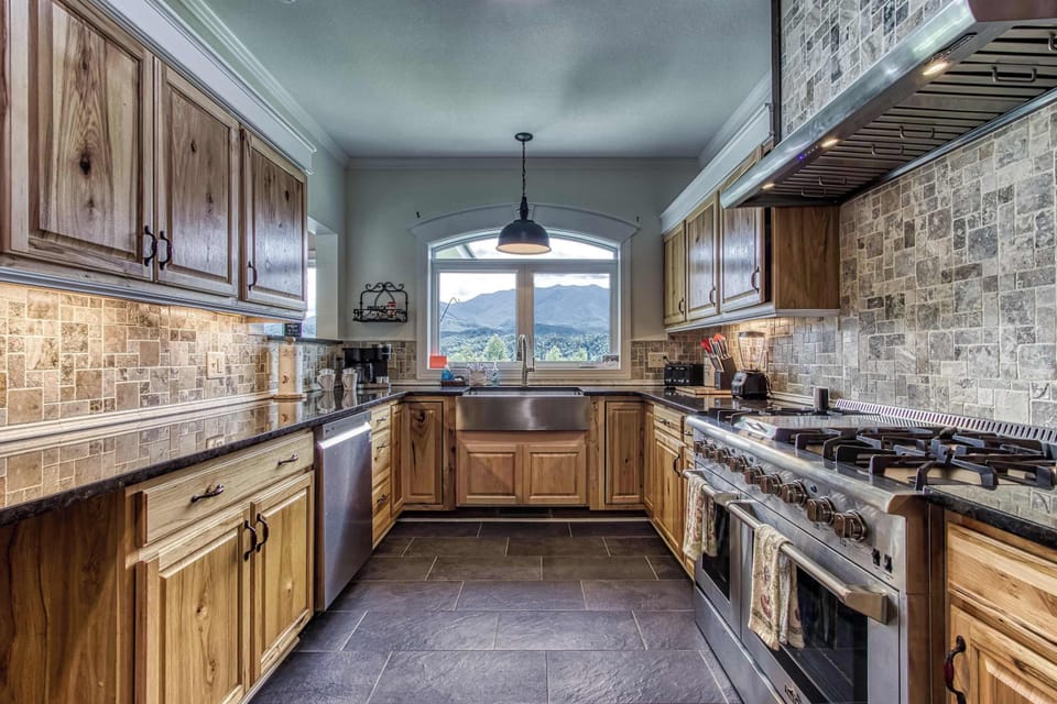 The spacious kitchen is fully equipped with modern appliances and plenty of counter space for preparing delicious meals. Warm wooden cabinetry and bright lighting create a welcoming atmosphere.