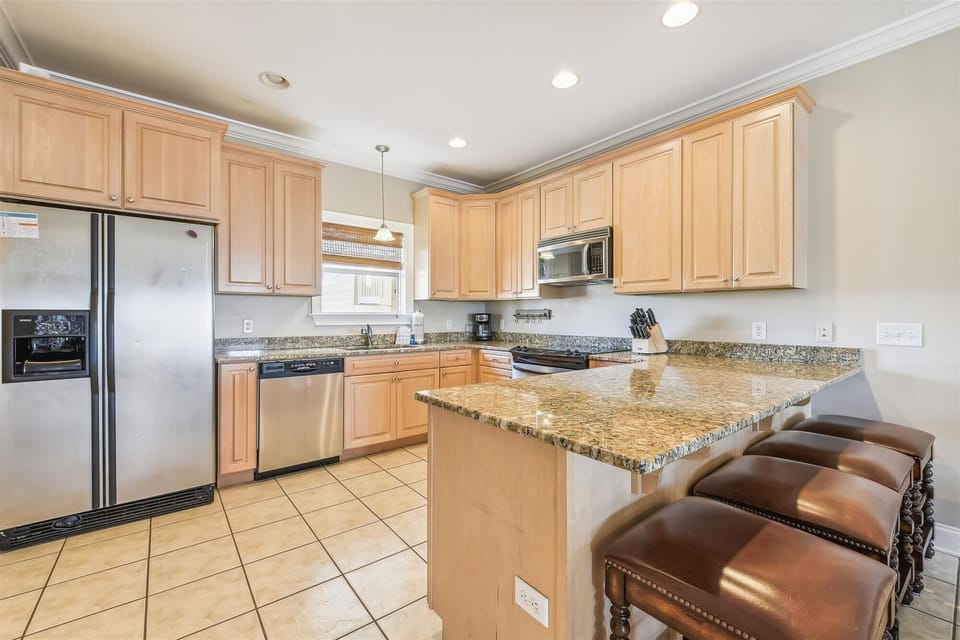 Full Size Kitchen with Stainless Steel Appliances and Bar Seating