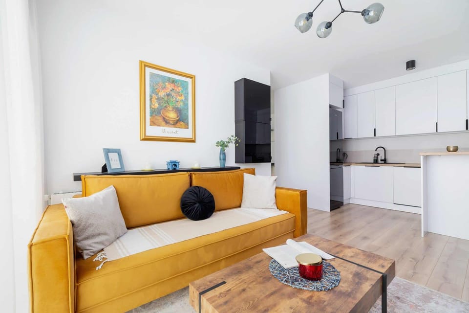 Another angle of the living room showcasing the mustard sofa and a stylish rug.
