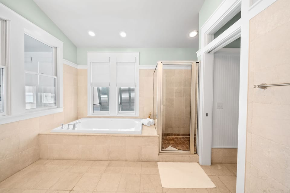 Unwind in your spa-like bathroom featuring a deep soaking tub, separate glass shower, and elegant stone finishes for pure relaxation.