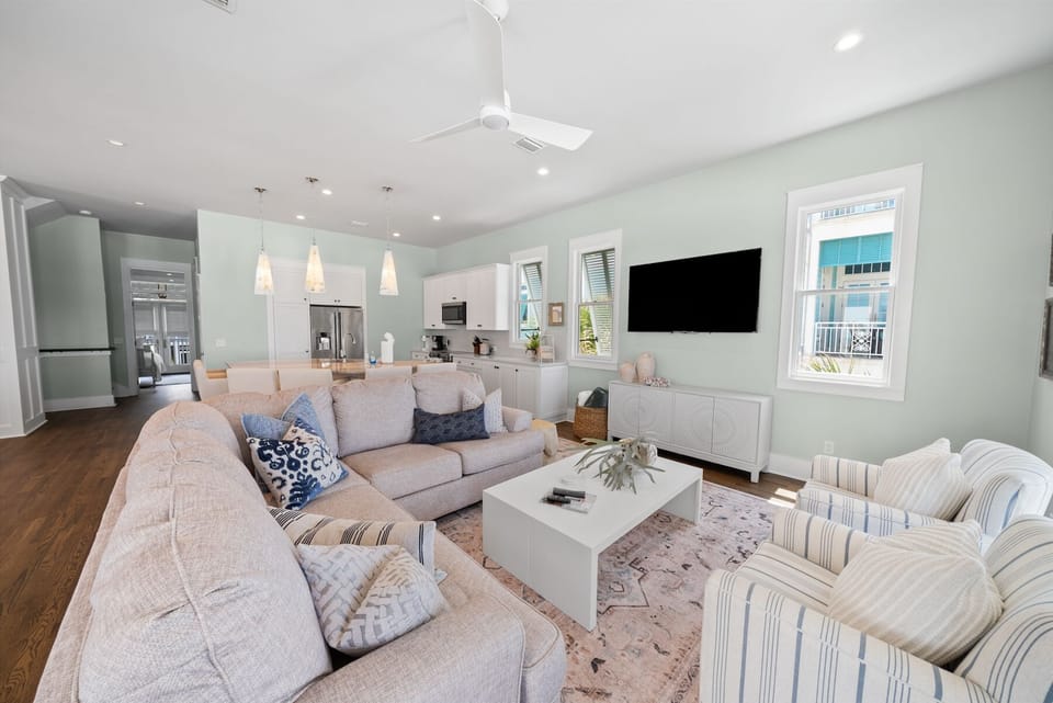 Unwind in your spacious living room featuring plush sectional seating, modern kitchen access, and entertainment center for perfect relaxation.