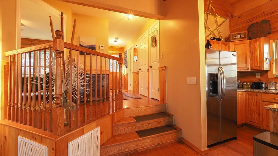 Two steps down from entry hallway to the open area with Kitchen and living room and deck