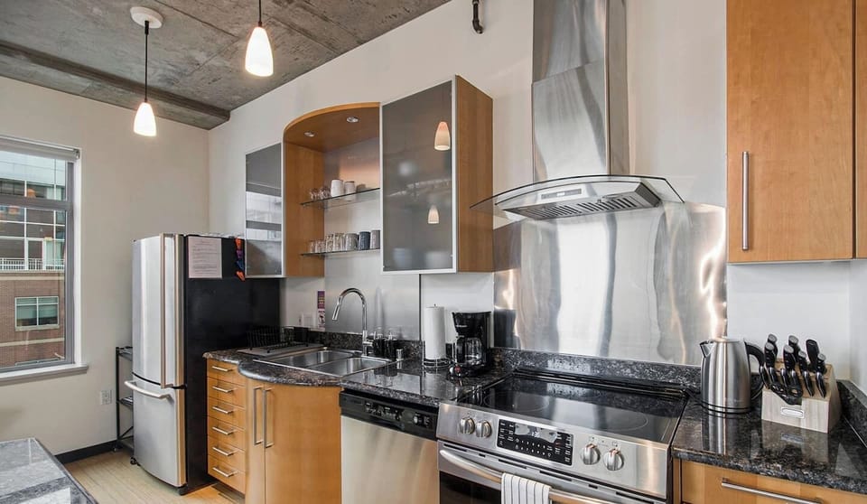 - Fully stocked kitchen features sleek appliances and glossy granite countertops
- Open shelving and vented range hood add style to the functional layout
- Everything you need for cooking, from coffee to full meals, is right here