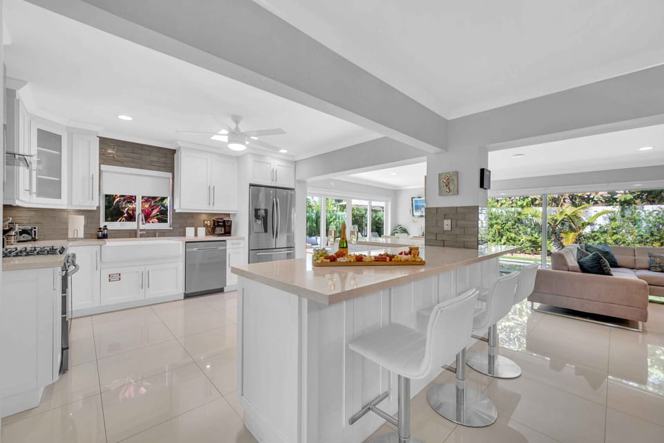 The large open kitchen is equipped with state of the art appliances for every gourmet chef. Extra counter space and a perfect view of the living room, dining room, and backyard oasis. Extra seating, featuring bar stools that seat 6.