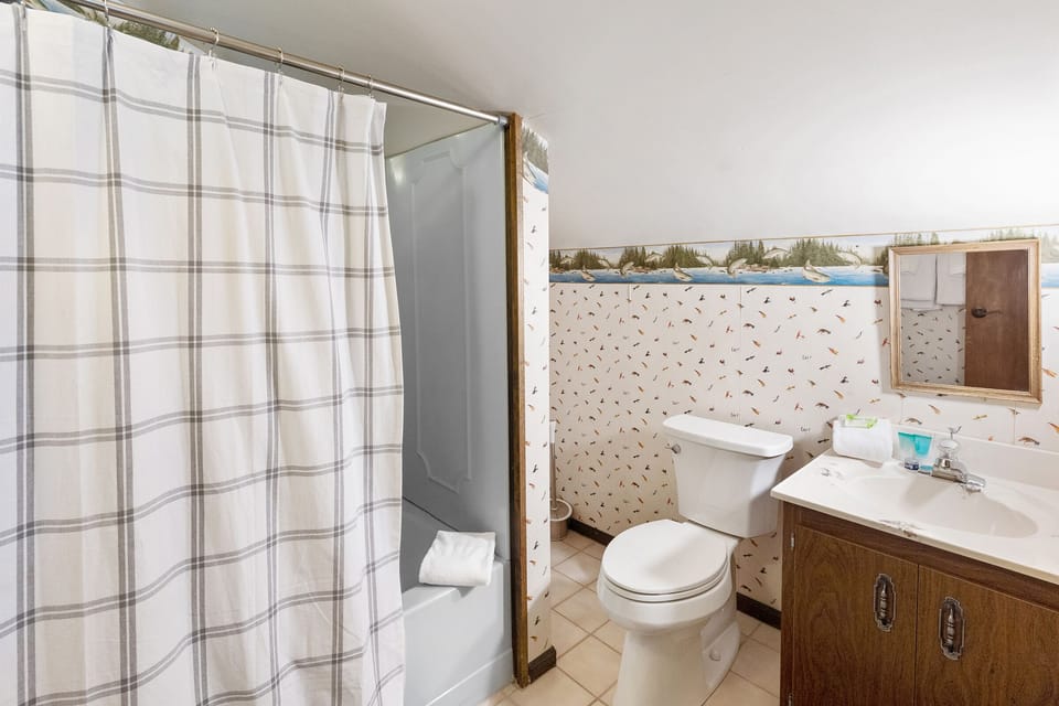 Combo shower/tub, toilet  and vanity sink located the loft bathroom