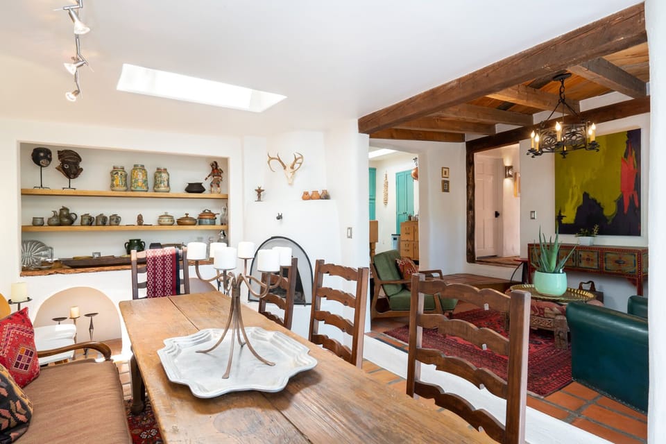 A dining room with a wooden table and chairs.