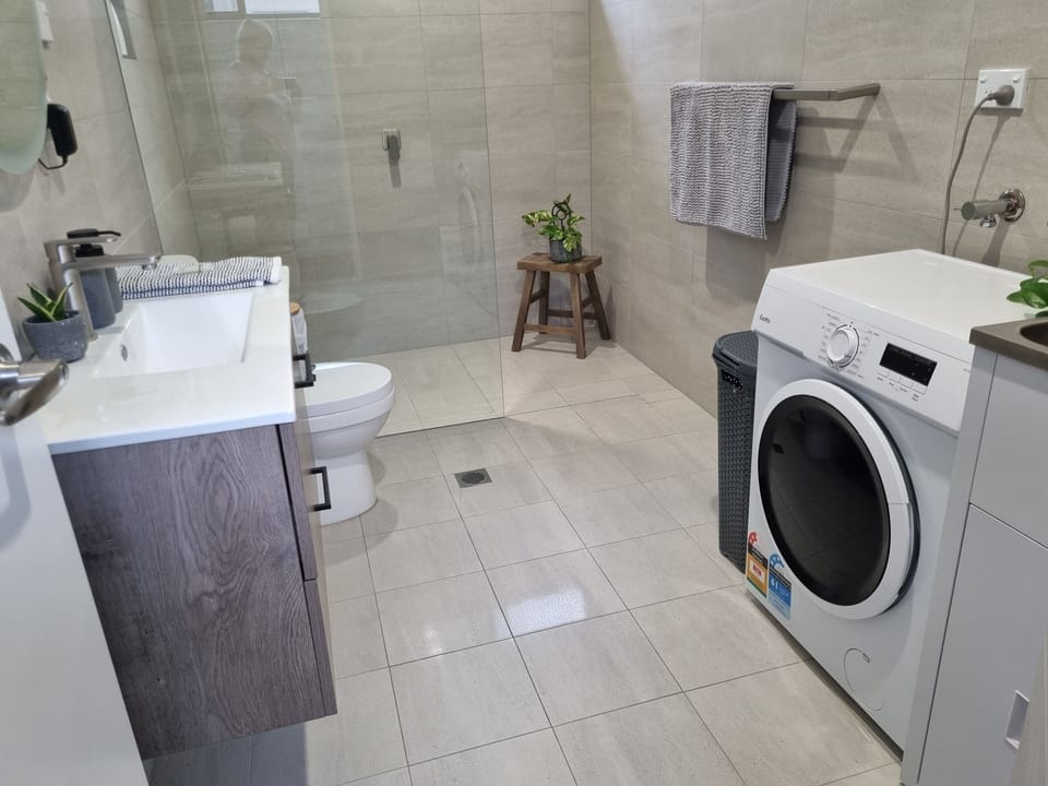 Full bathroom with walking shower and laundry facilities 