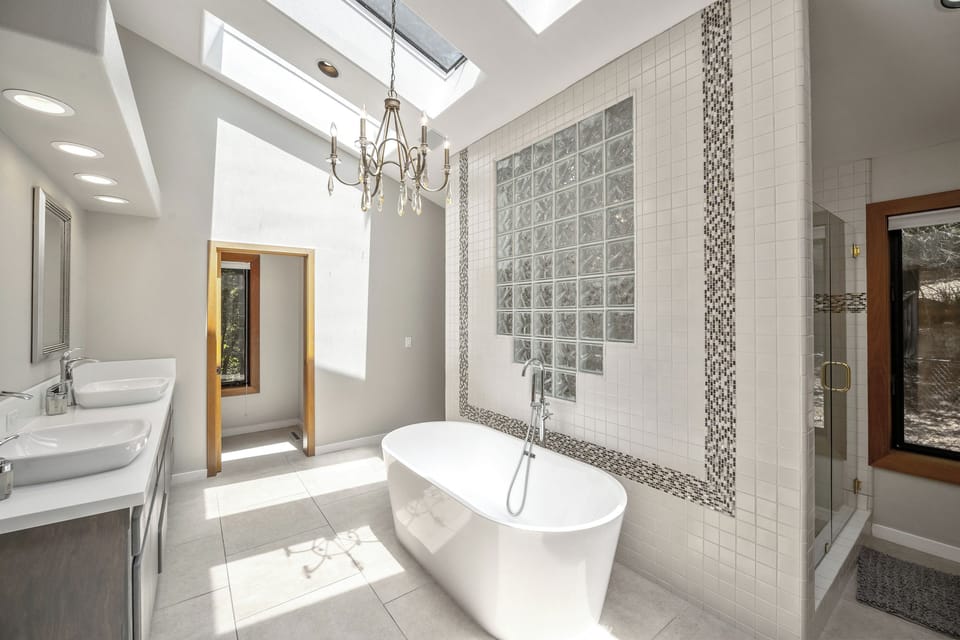 Ensuite bathroom attached to the primary bedroom. Soaking tub, two sinks, large shower with two shower heads, and two walk-in closets.