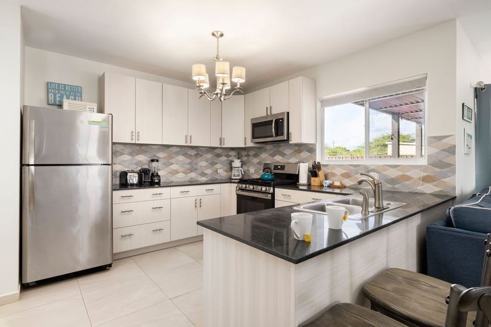 This spacious kitchen is equipped with all necessary appliances like stove, oven, coffee maker, microwave and fridge.