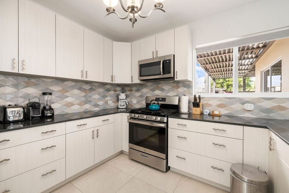 This spacious kitchen is equipped with all necessary appliances like stove, oven, coffee maker, microwave and fridge.