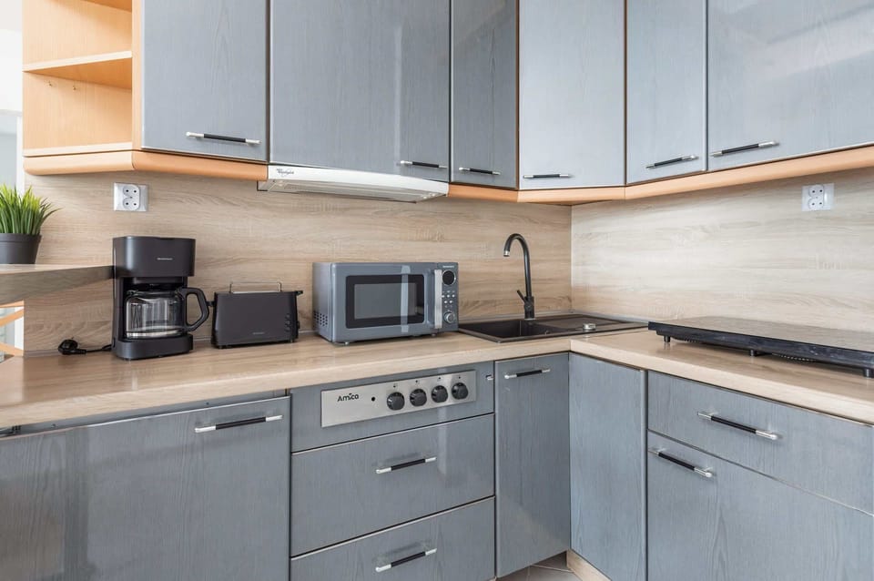 A close-up of the kitchen showcasing the stove, microwave, and sleek cabinetry.
