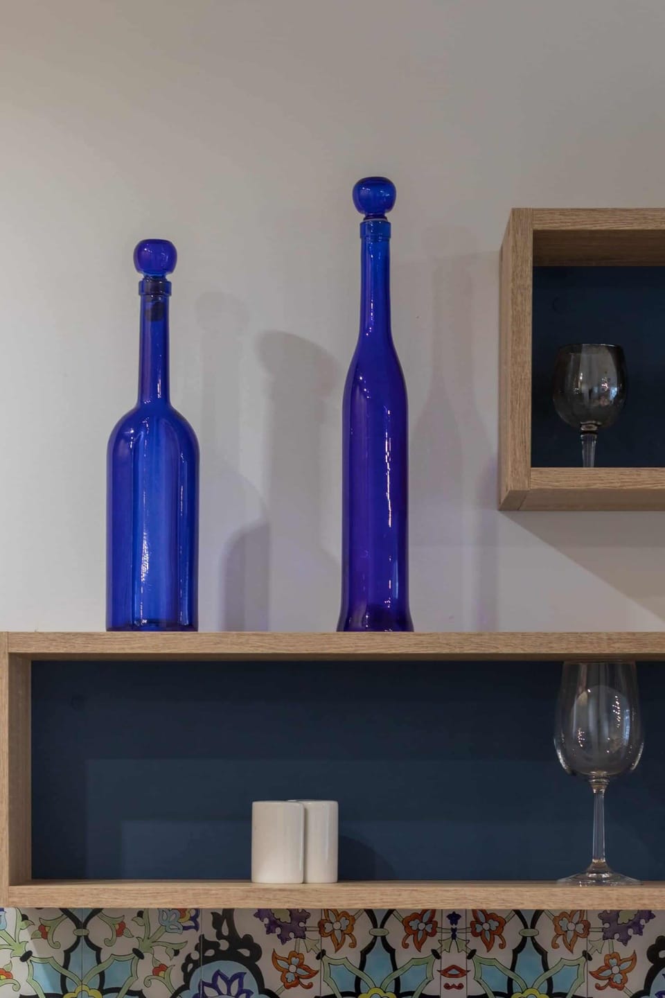 A decorative detail with blue bottles and a wooden shelf, adding personality to the space.
