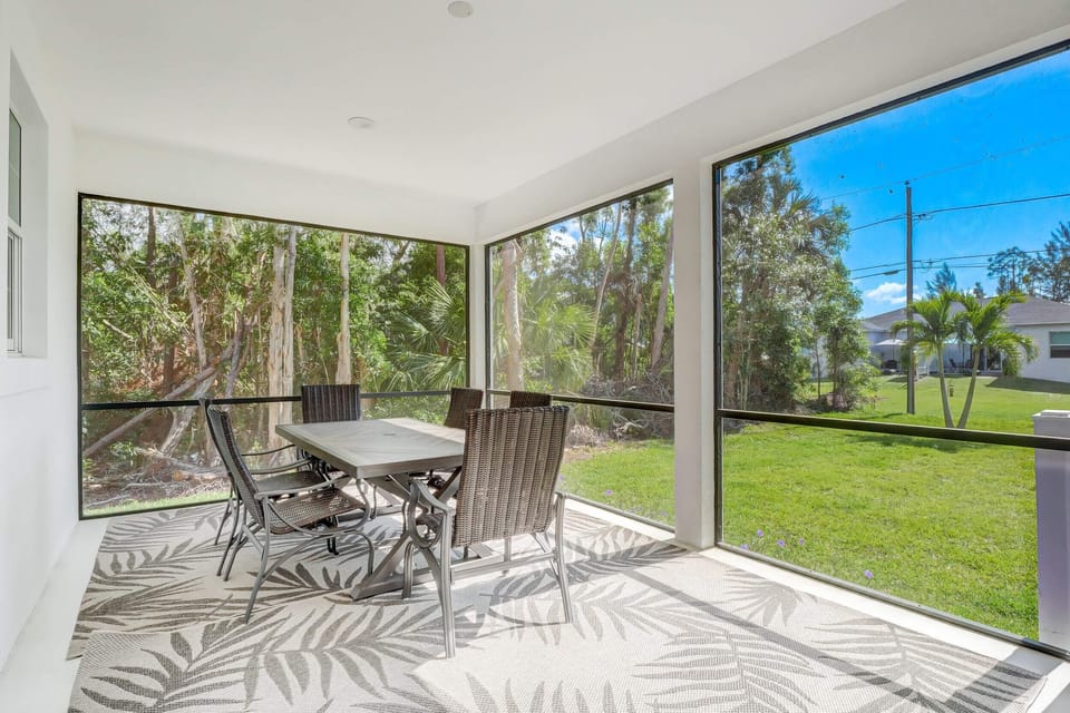 The Back Porch Our Our Home is Screened and Has a Dining Set and An Electric Grill