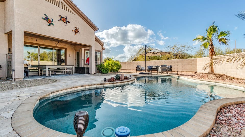 Close up from fire pit looking at pool, billiards, and out door furniture