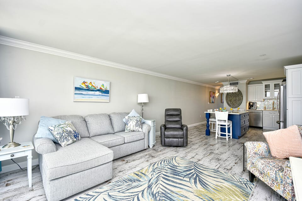 Living room has a chaise and a swivel rocker recliner along with extra seating. 