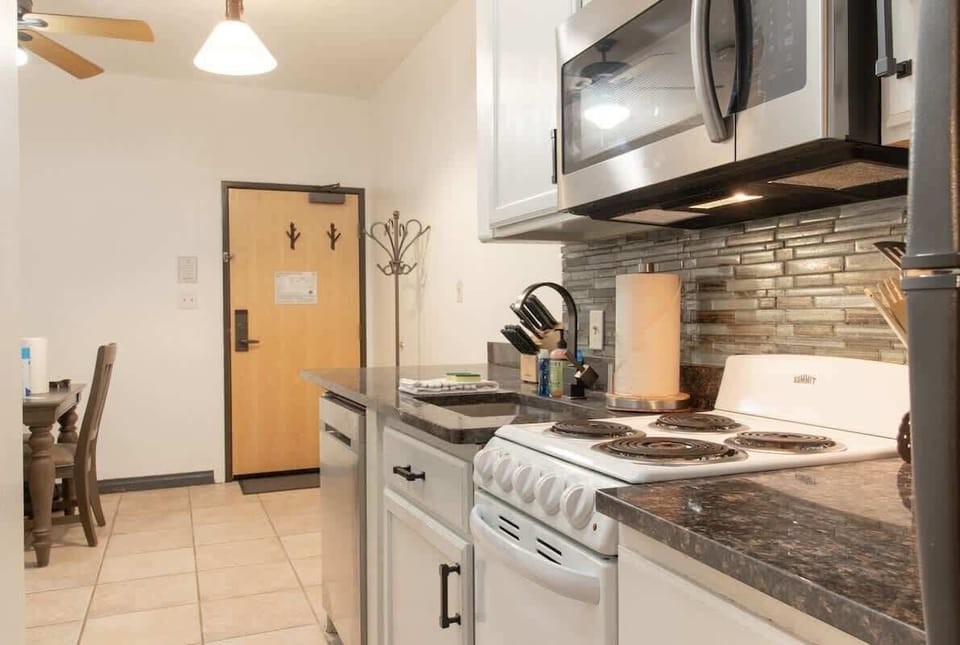 Step into your stylish kitchen, where modern amenities and sleek design await! You'll find everything you need to whip up a delicious meal. Appreciate the granite countertops, elegant cabinetry, and stainless steel appliances that add a touch of luxury to your stay.(Kitchen with cooking basics)