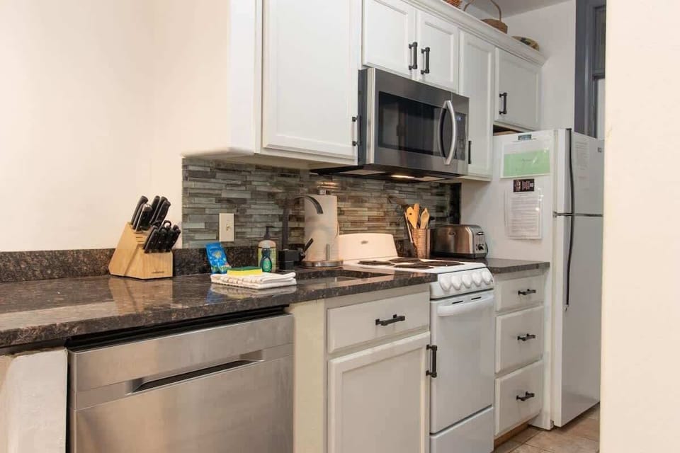 Love the convenience of a fully equipped kitchen, featuring granite countertops and a complete set of appliances. You can easily prepare your favorite dishes here, surrounded by the chic backsplash and ample storage space.