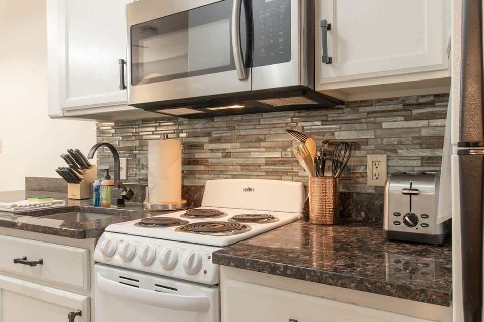 Admire the beautiful granite countertops and the seamless blend of stainless steel appliances in this well-appointed kitchen. It’s a chef's delight, perfect for preparing meals with ease and enjoying the modern, stylish atmosphere.