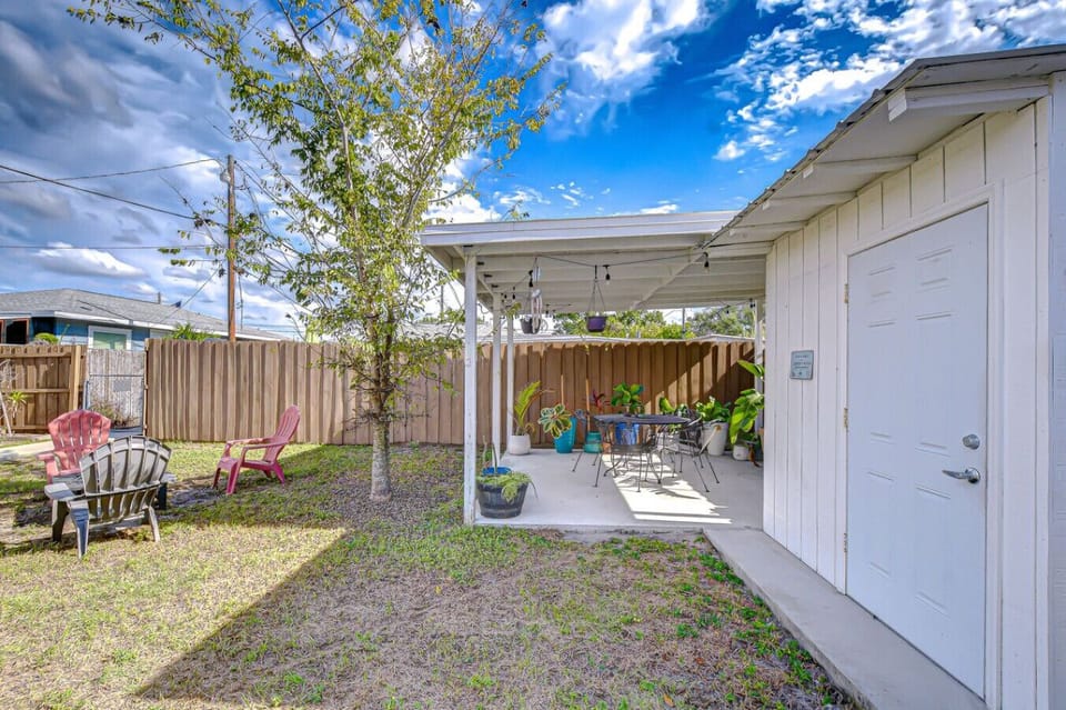Enjoy this sunny yard featuring both a shaded pergola and open seating areas perfect for gatherings.