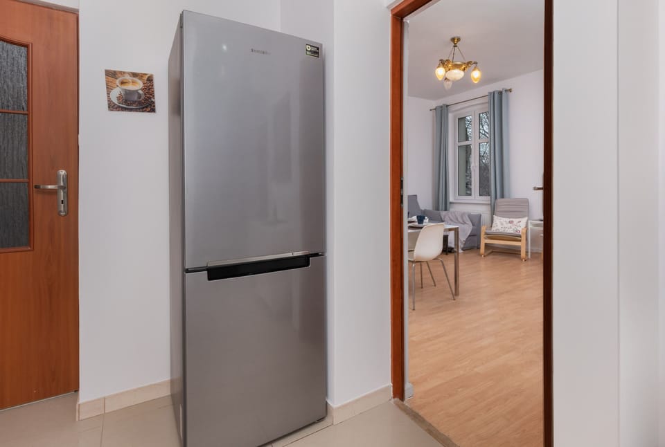 A kitchen corner with a fridge, stove, and modern amenities.
