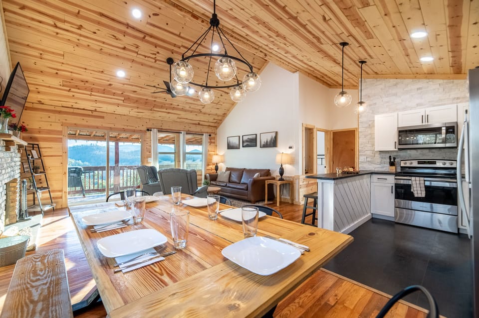 Living Room, dining area and kitchen with vaulted ceilings and natural light.
