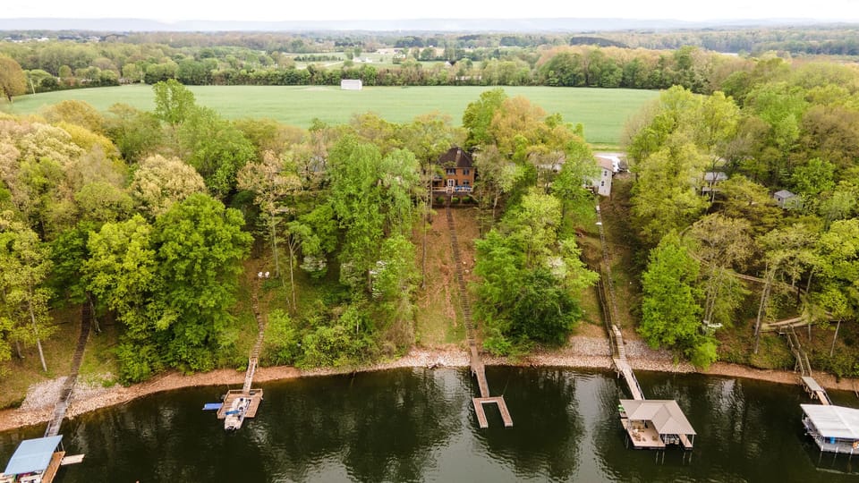 Drone shot from lakeside of home.  Note - This shows old, prior dock. 