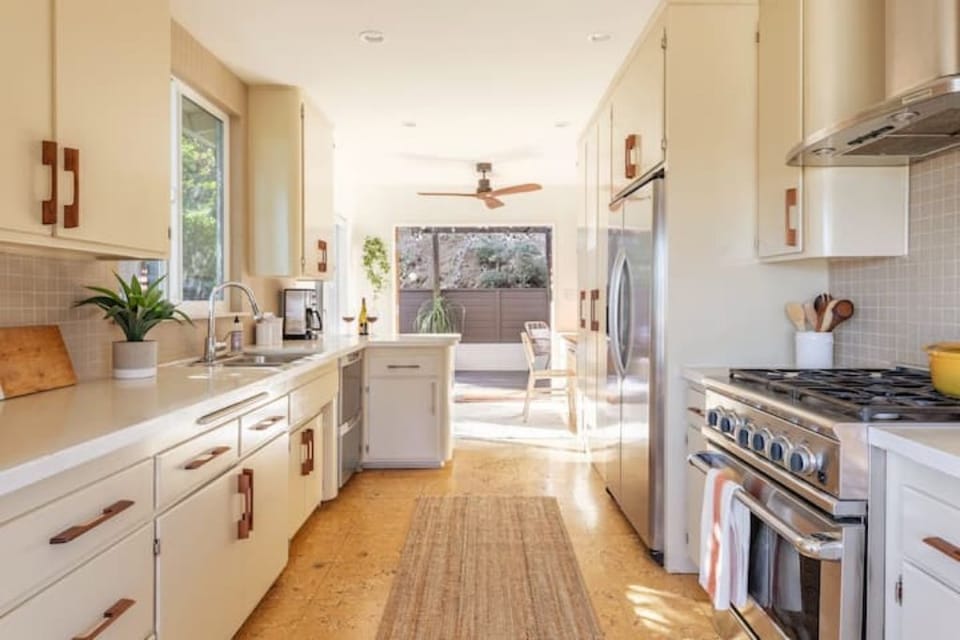 Full kitchen, leading onto work area and out to patio via French doors. 