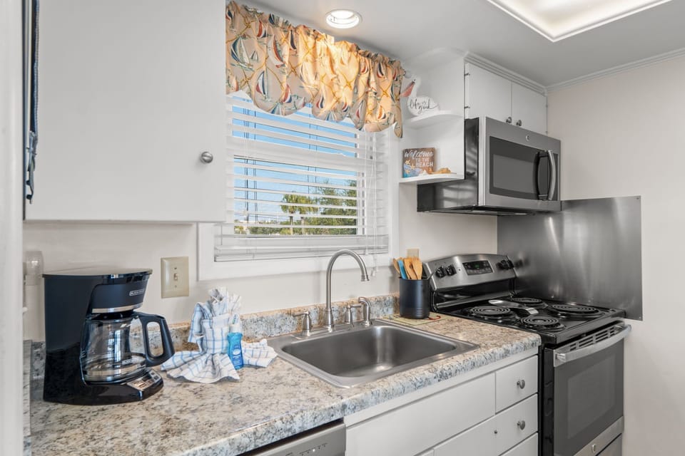Your fully equipped kitchen features granite countertops, stainless steel appliances, and charming coastal-themed touches for effortless meal preparation.