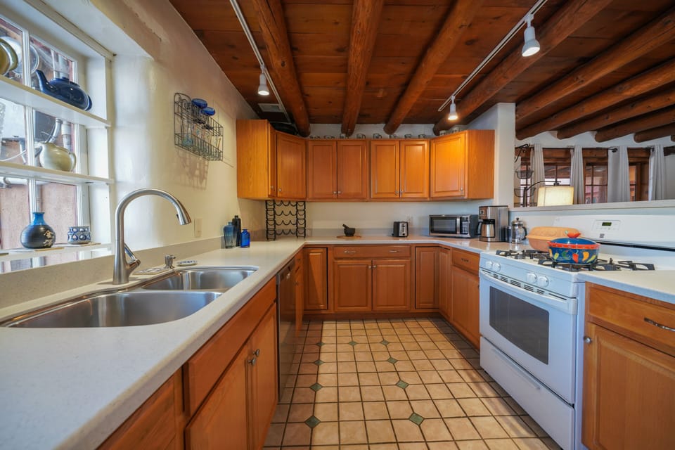A kitchen with a stove, sink, and a window.