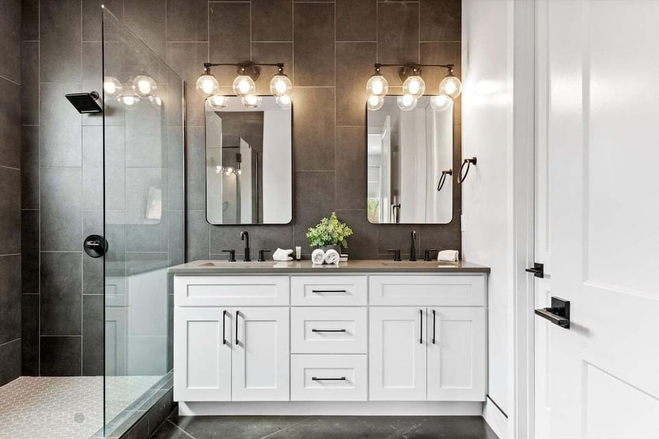 Attached to Guest Room 4 is the fourth Guest Bathroom. It hosts double vanity sinks for mutual accessibility, and the unique stone adds a trendy and industrial flair to this guest room retreat.
