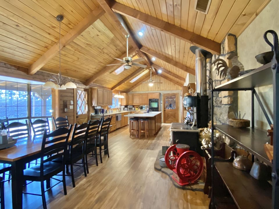 Combined kitchen and dining area with large bay window view to back patio