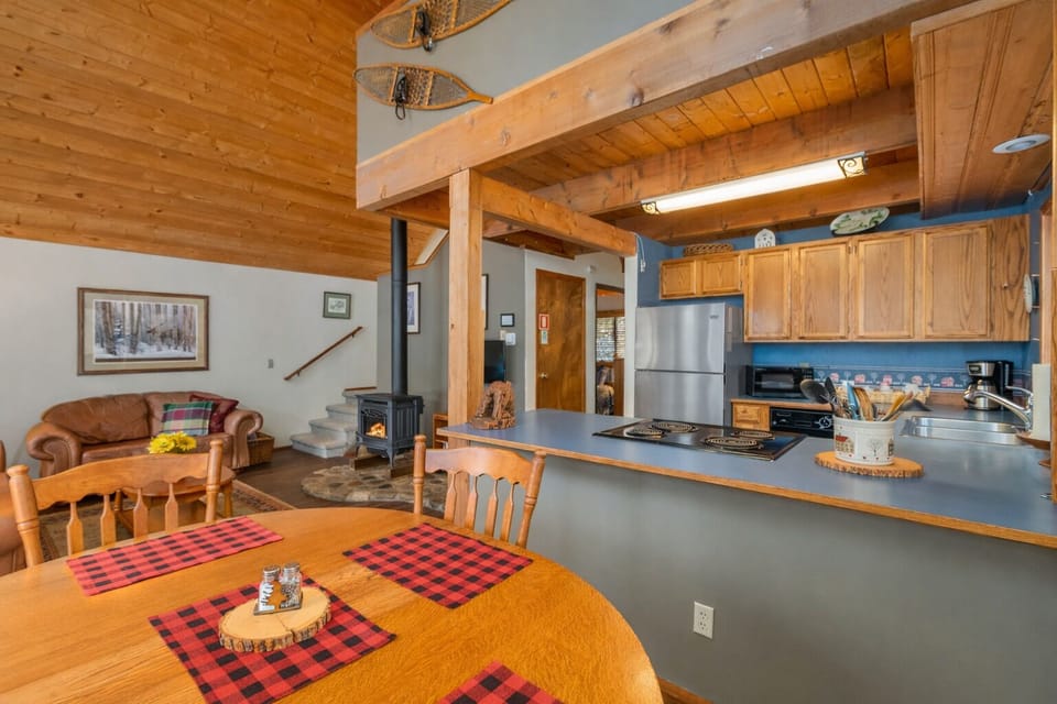 The mountain kitchen awaits with warm wood cabinets, modern appliances, and everything needed for memorable meals together.