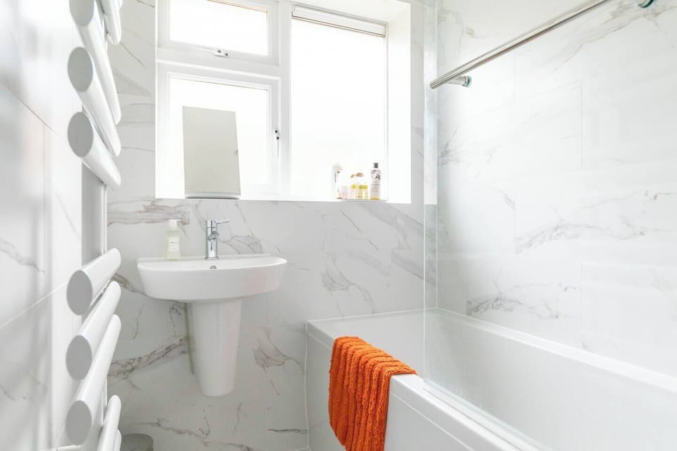 Bathroom basin and bath with overhead shower