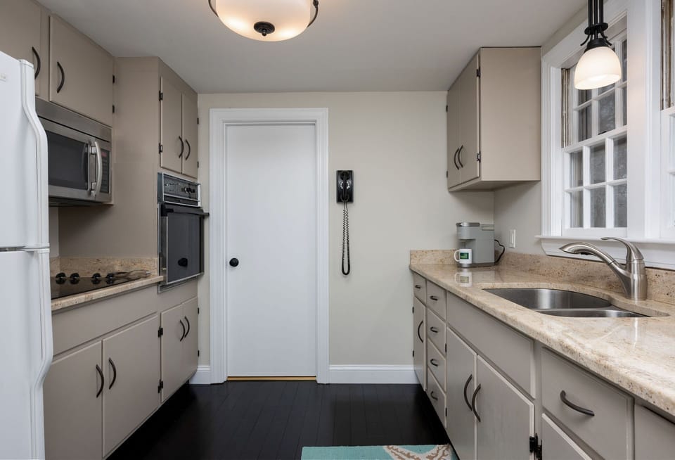 Spacious galley kitchen with a bathroom on the far side that is also connected to the hallway - 177 Old Stage Road Centerville Cape Cod - Family Tides - New England Vacation Rentals