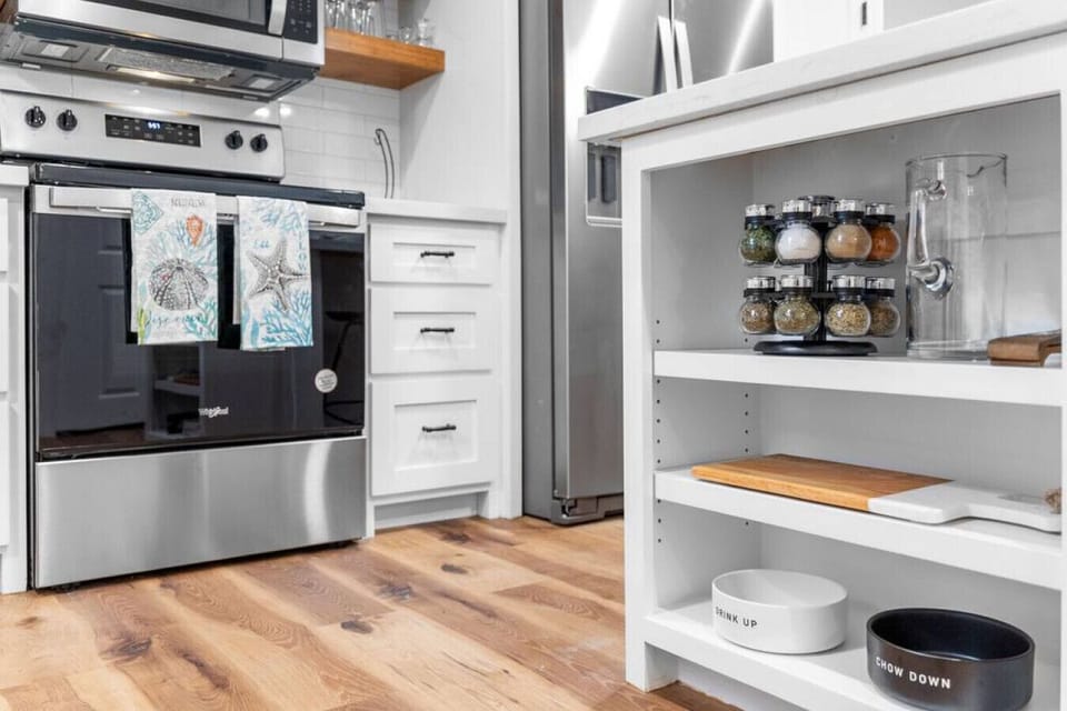 Pantry storage with spices, cutting boards, and pet bowls conveniently located in the kitchen.