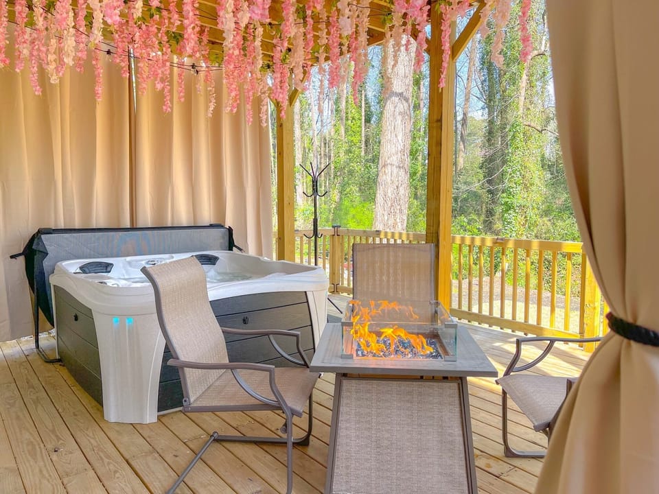 Enjoy a beautiful nature scenery while you relax in the brand new 4-5-person hot tub with 20 hydrotherapy jets, bench seating, furniture near a fire pit, and privacy curtains. 3 of 3 decks.