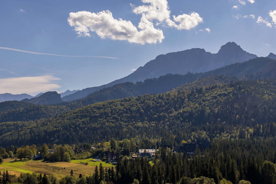 A breathtaking mountain landscape with peaks and clouds under a bright sky.
