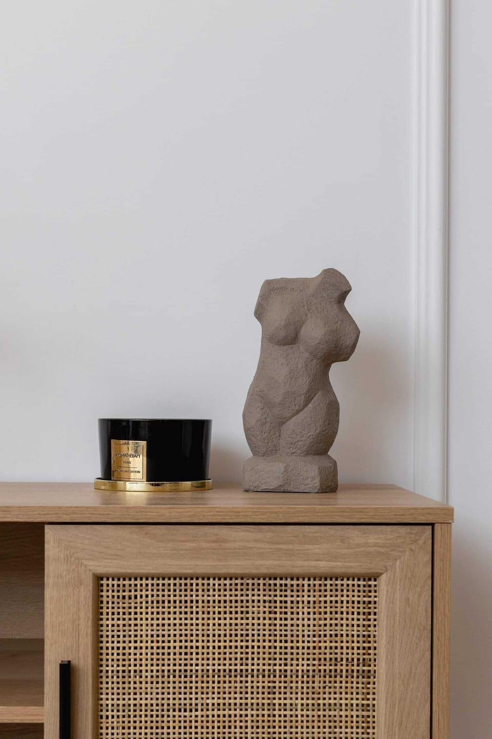 A close-up of a decorative piece on a stylish wooden sideboard.
