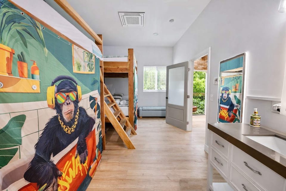 Art-Filled Resort Hallway Featuring Colorful Wall Mural, Bunk Room Entry, and Open Walkway — Designed for Youthful Energy, Creativity, and Easy Flow Between Spaces