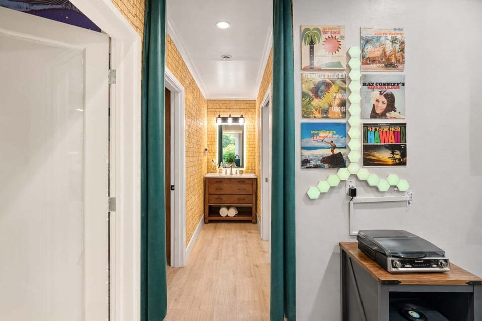 Stylish Resort Hallway with Decorative Wall Art, Soft Curtains, and Vanity View — A Creative, Well-Lit Transition Space Connecting Bedrooms and Bathrooms with a Relaxed, Youthful Vibe